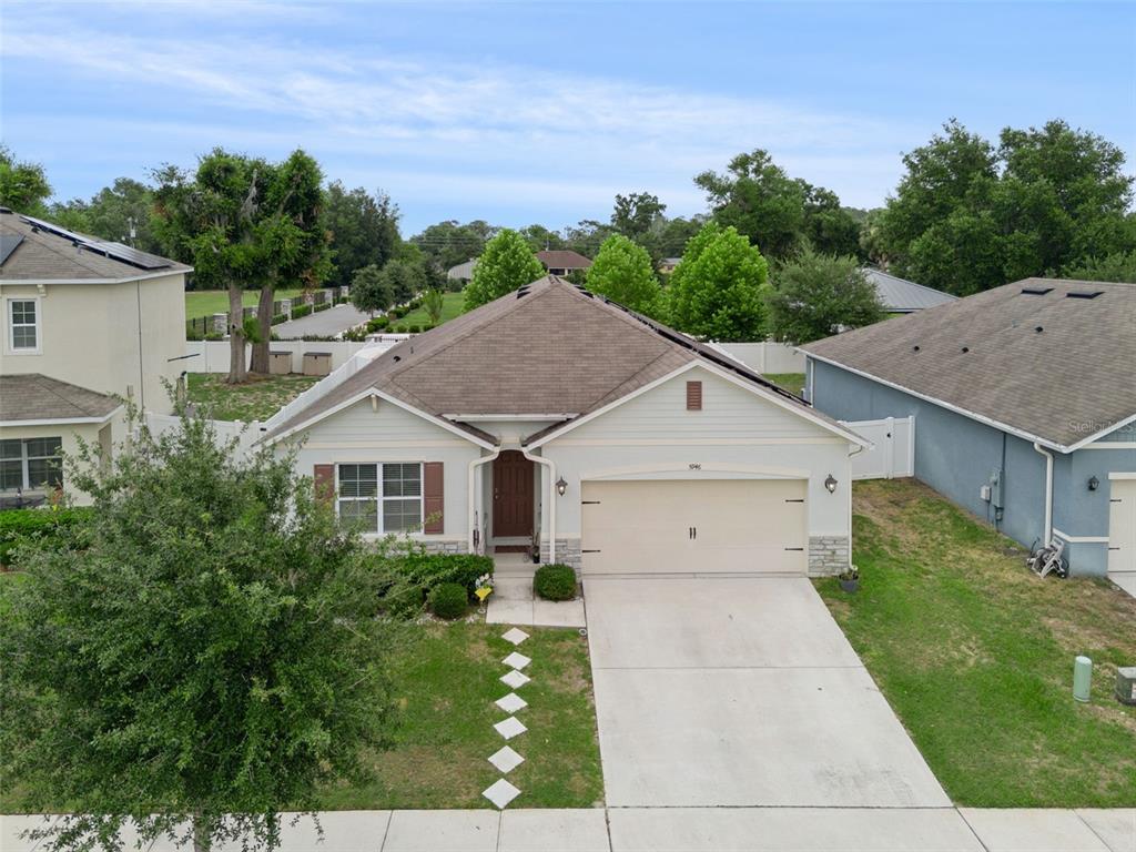 A single-story suburban house with a brown roof, beige siding, and a two-car garage — 5946 CHURCHILL SQ WAY, GROVELAND, FL