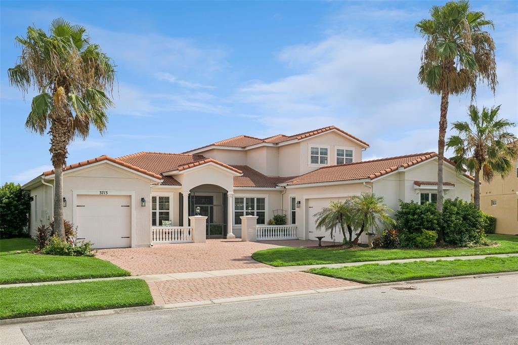 A two-story house with a terracotta tile roof, a brick driveway, and two palm trees — 3713 DOCKSIDE DR, KISSIMMEE, FL