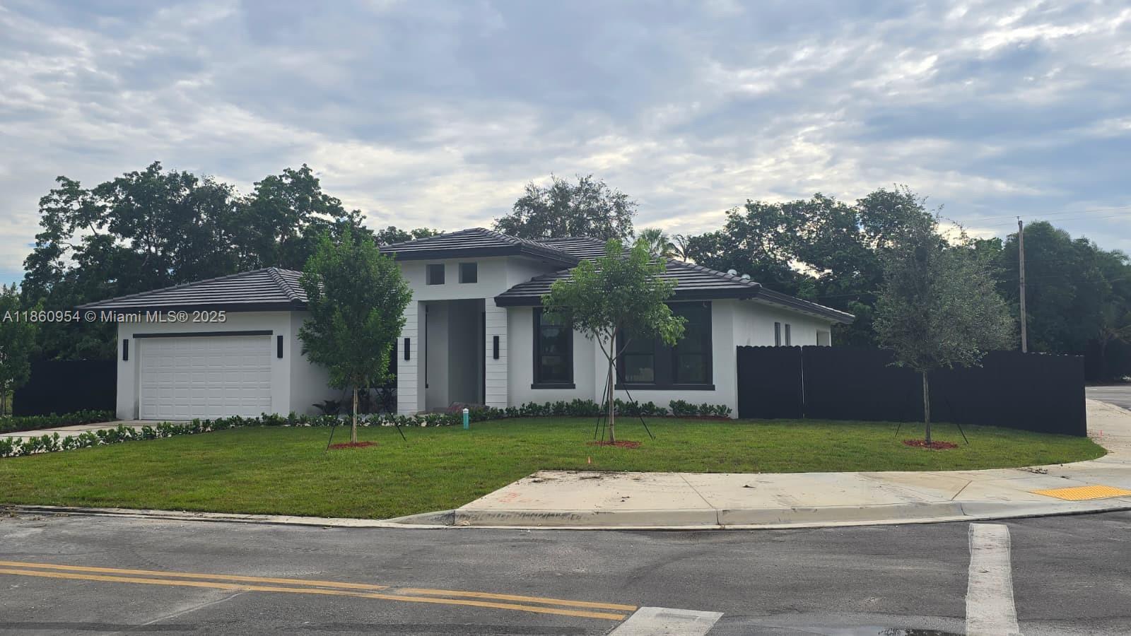 A modern single-story house with a white exterior, dark roof, and black fence — 28361 SW 172nd Ct, Miami FL 33030, MIAMI, FL
