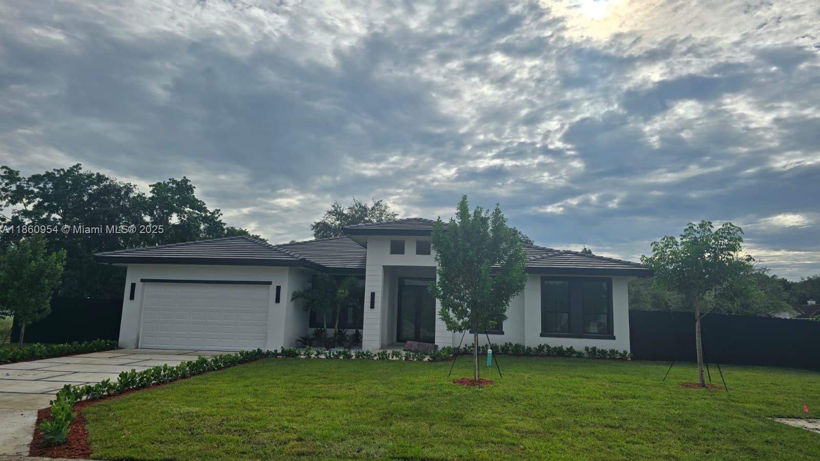 A modern single-story house with a white exterior, dark roof, and a two-car garage — 28361 SW 172nd Ct, Miami FL 33030, MIAMI, FL