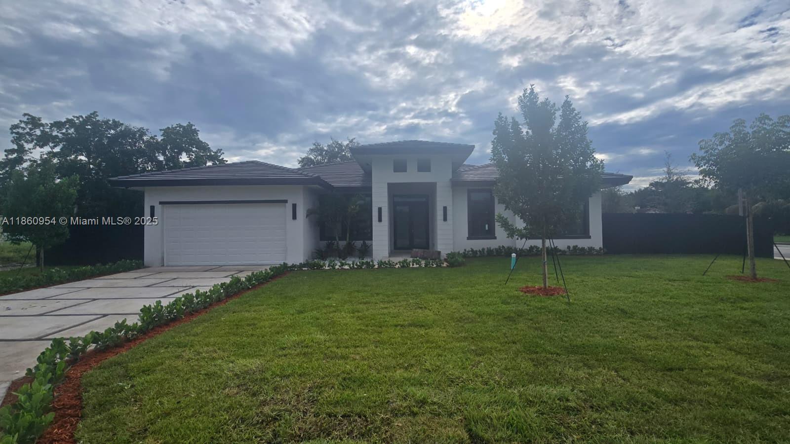 A modern single-story house with a white exterior, dark roof, and a paved driveway — 28361 SW 172nd Ct, Miami FL 33030, MIAMI, FL