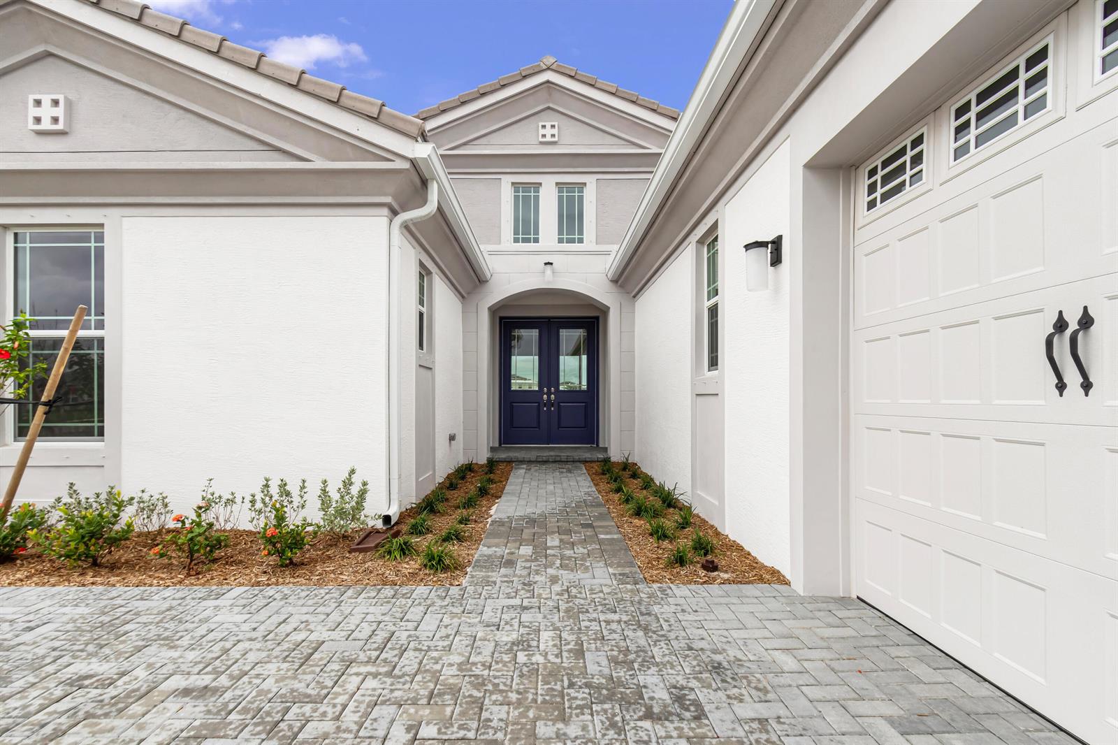 A paved walkway leads to the dark blue double front doors of a white house — 5182 Liberty Lane, Westlake FL 33470, WESTLAKE, FL