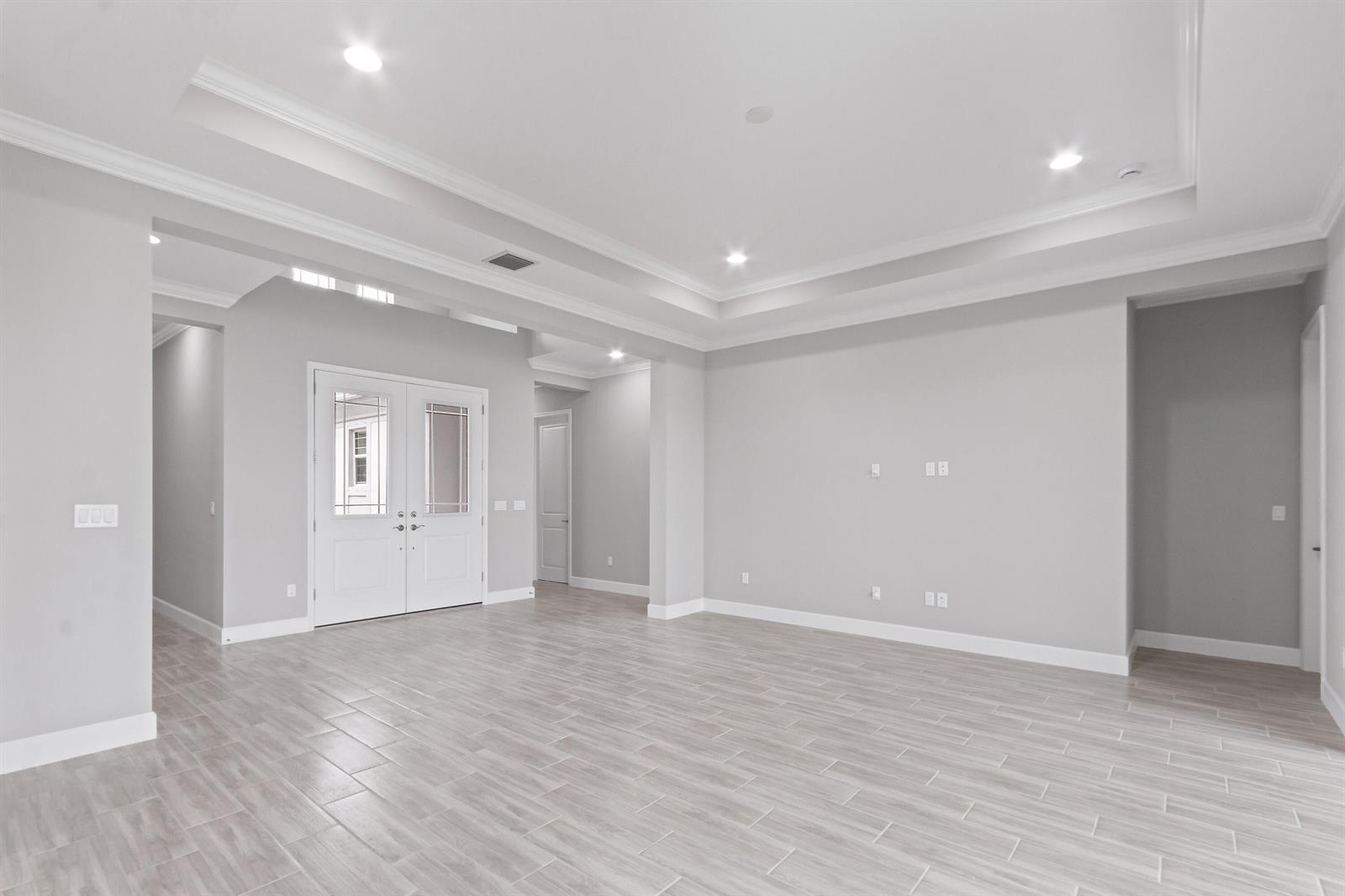 An empty room with light gray walls, a tray ceiling, and wood-look tile flooring — 5182 Liberty Lane, Westlake FL 33470, WESTLAKE, FL