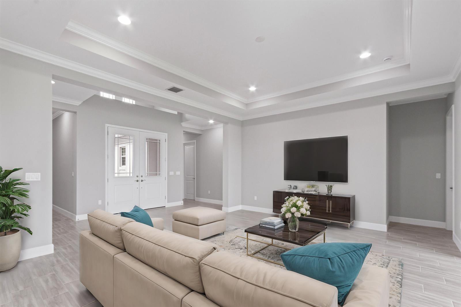 A living room features a beige sectional sofa, a television, and light-colored tile flooring — 5182 Liberty Lane, Westlake FL 33470, WESTLAKE, FL