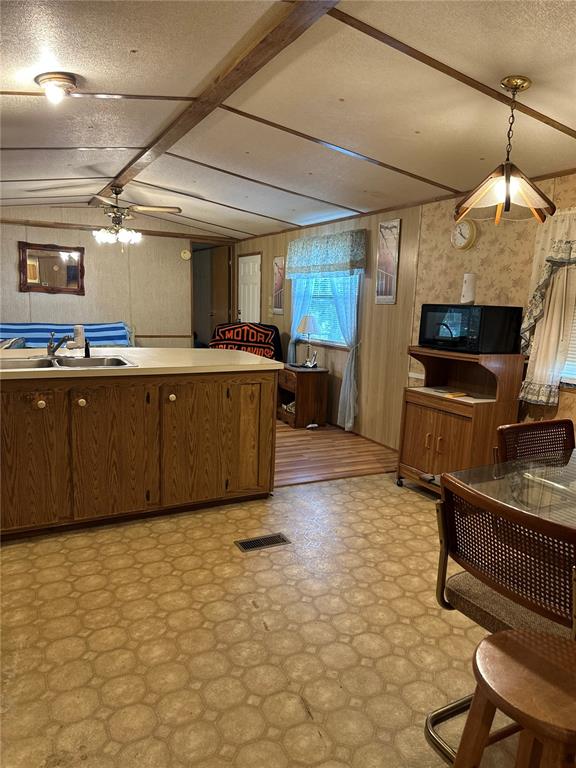 A kitchen with wood cabinets, a center island, and a dining area with a pendant light — 13059 NE 44TH LANE, SILVER SPRINGS, FL