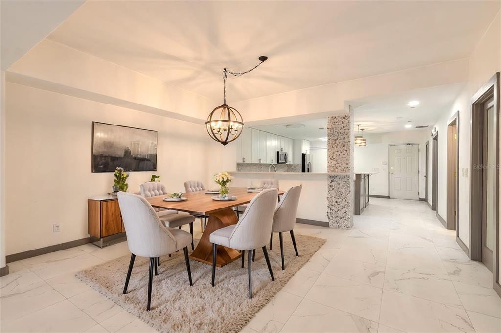 A dining room with a wooden table, upholstered chairs, and a chandelier on tile floors — 424 LUNA BELLA LANE UNIT 416C, NEW SMYRNA BEACH, FL