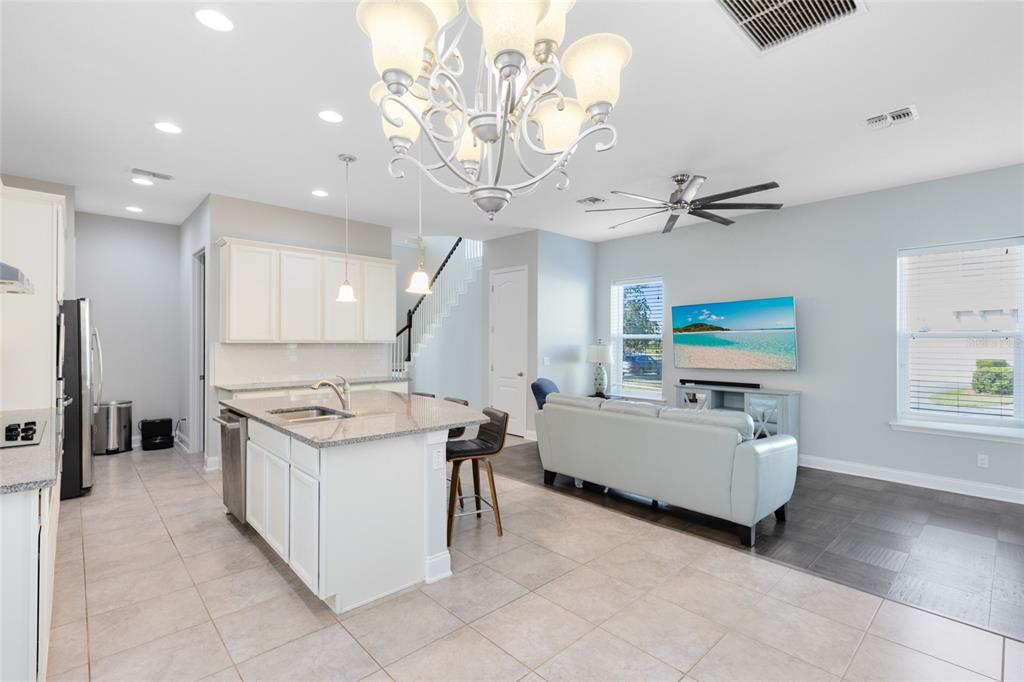 A dining area features a wooden table, four chairs, a chandelier, and two windows — 7749 LAUREATE BOULEVARD, ORLANDO, FL