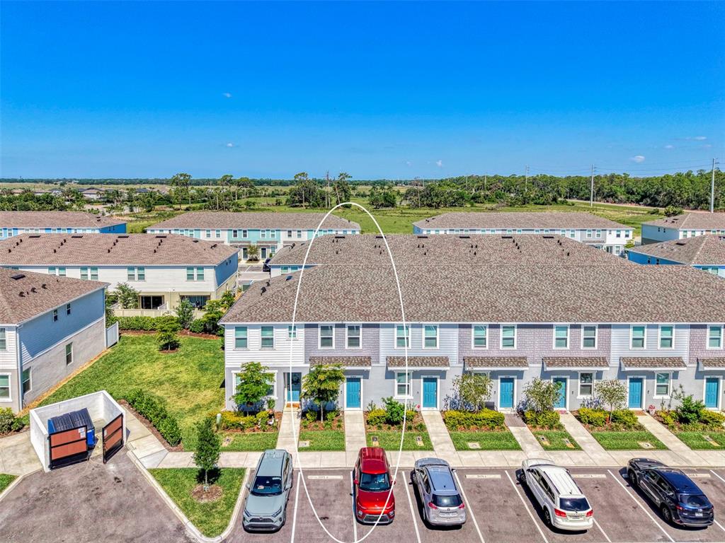 An aerial view shows a row of townhouses with a red car parked in front — 8540 DAYBREAK STREET, SARASOTA, FL
