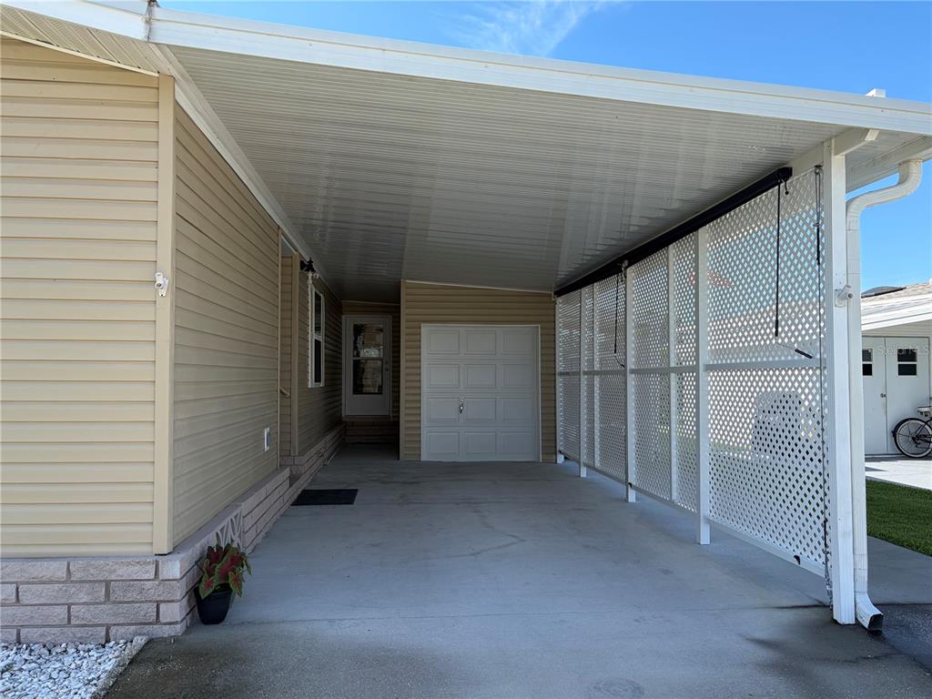 A covered carport with a white lattice privacy screen and a small attached storage garage — 57 STRAPHMORE DRIVE, HAINES CITY, FL