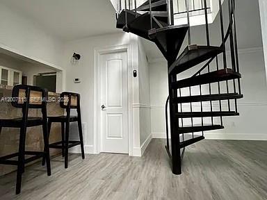 A spiral staircase stands next to a kitchen counter with two bar stools — 3209 Bird Ave, Miami FL 33133, MIAMI, FL