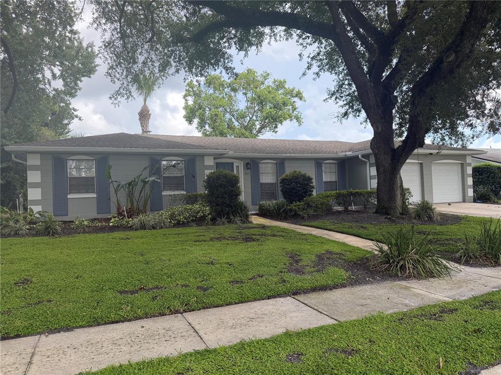 A single-story house with a gray exterior, a front walkway, and mature landscaping — 411 MONTICELLO DRIVE, ALTAMONTE SPRINGS, FL