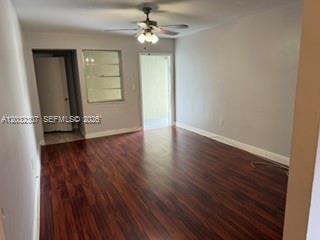 An empty room with dark wood flooring, a ceiling fan, and two doorways — 7601 Venetian St # 4, Miramar FL 33023, MIRAMAR, FL