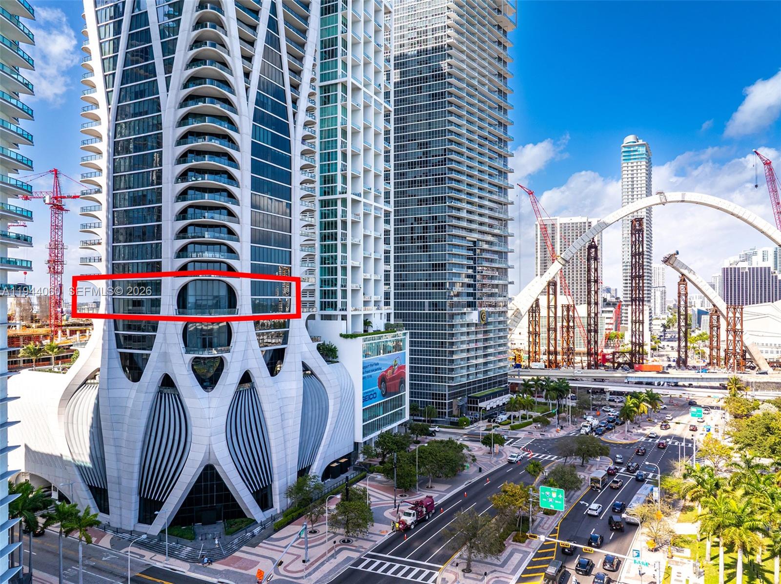 A spacious room with white marble floors, floor-to-ceiling windows, and a balcony overlooking water — 1000 Biscayne Blvd, Miami FL 33132, MIAMI, FL