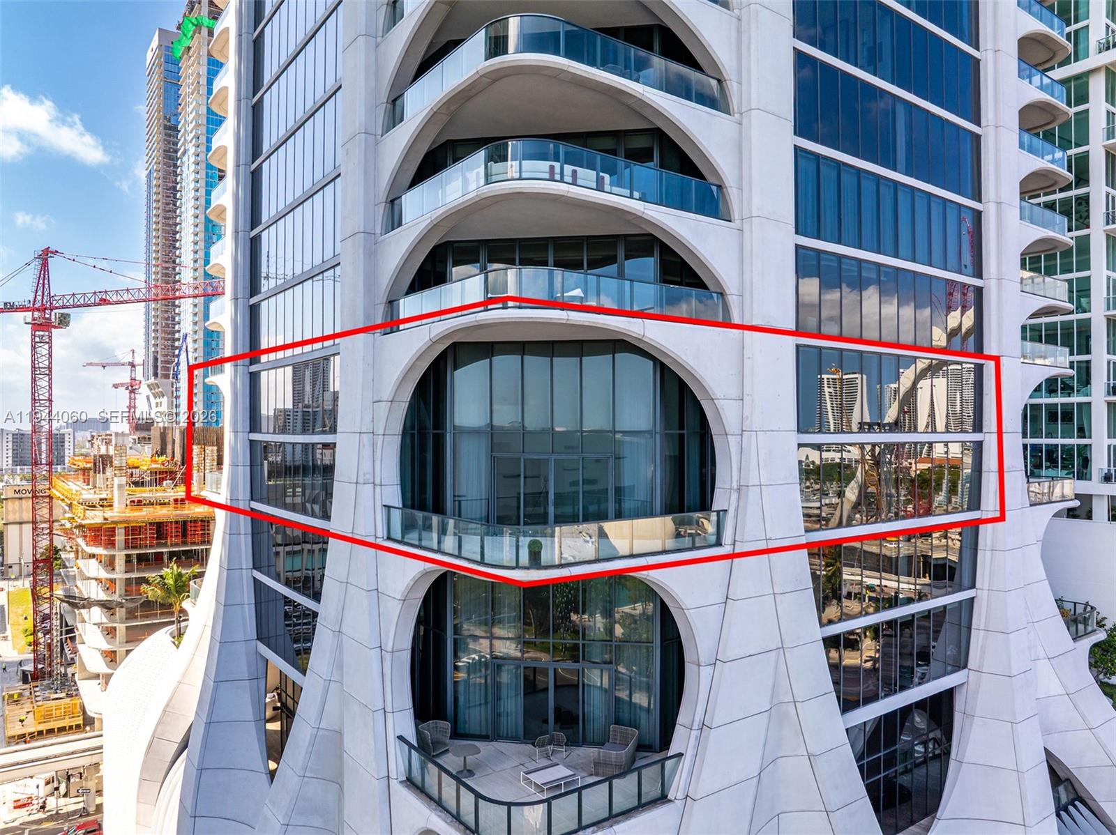 A spacious, empty room features white marble floors, high ceilings, and floor-to-ceiling windows with views — 1000 Biscayne Blvd, Miami FL 33132, MIAMI, FL
