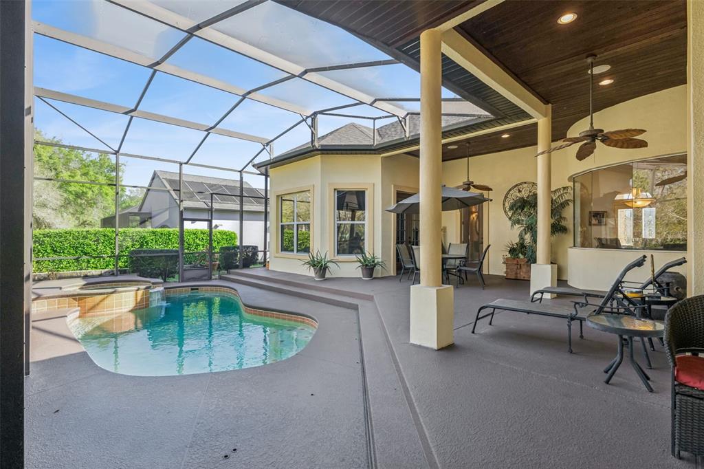 A screened-in patio features a swimming pool, a hot tub, and a covered seating area — 814 MIAMI SPRINGS DRIVE, LONGWOOD, FL
