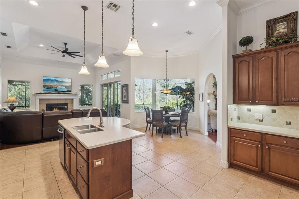 A kitchen with a center island and tile floors opens to a living room and dining area — 814 MIAMI SPRINGS DRIVE, LONGWOOD, FL