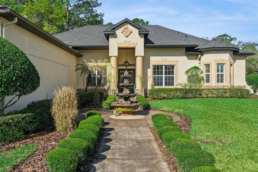 A single-story house features a stone fountain on the walkway leading to the front entrance — 814 MIAMI SPRINGS DRIVE, LONGWOOD, FL