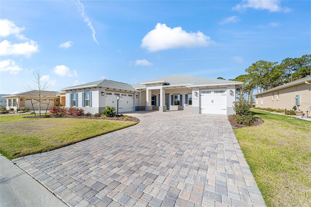 A single-story house with a paved driveway, two garage doors, and a covered entryway — 8176 SW 98TH TERRACE ROAD, OCALA, FL