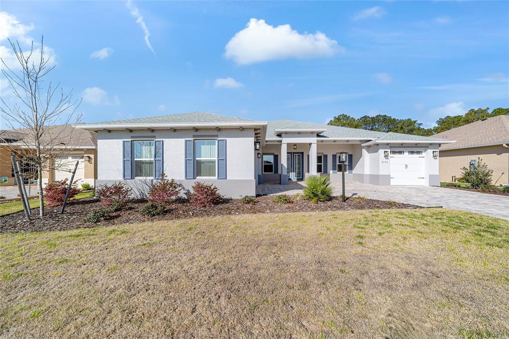 A single-story house with a light gray exterior, blue shutters, and a paved driveway — 8176 SW 98TH TERRACE ROAD, OCALA, FL