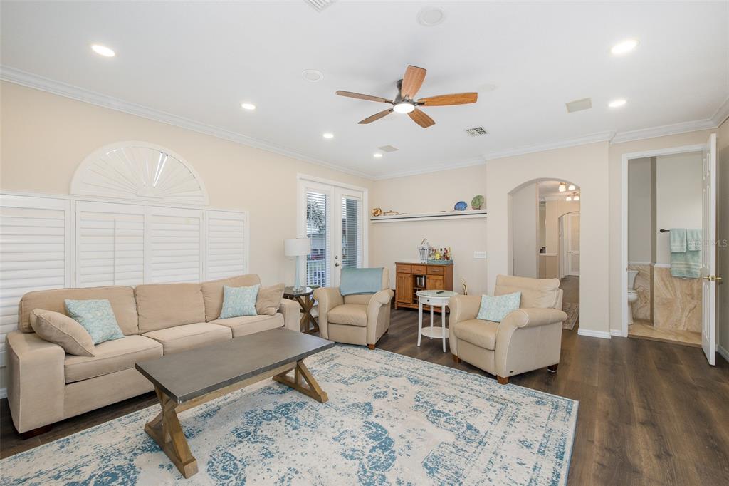 A living room features a beige sofa, two armchairs, a coffee table, and wood flooring — 3020 SHEPPARDS CROOK COURT, HOLIDAY, FL