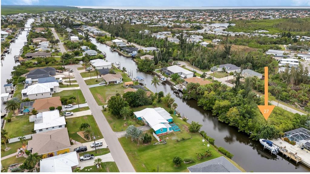 An aerial view shows a waterfront residential lot marked with an orange arrow and number — 3402 COLONY COURT, PUNTA GORDA, FL