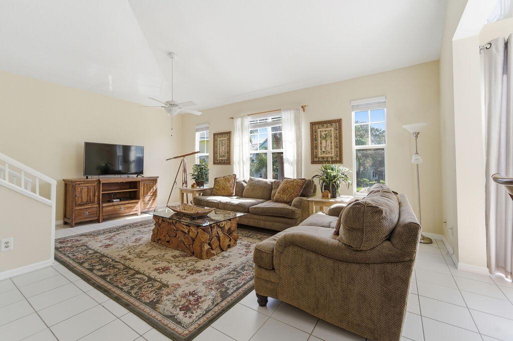 A living room features tile floors, a patterned area rug, two sofas, and a wooden coffee table — 1509 Mizzenmast Way, Jupiter FL 33477, JUPITER, FL