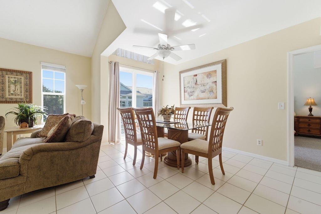 A dining area with a glass table and chairs sits next to a living room — 1509 Mizzenmast Way, Jupiter FL 33477, JUPITER, FL