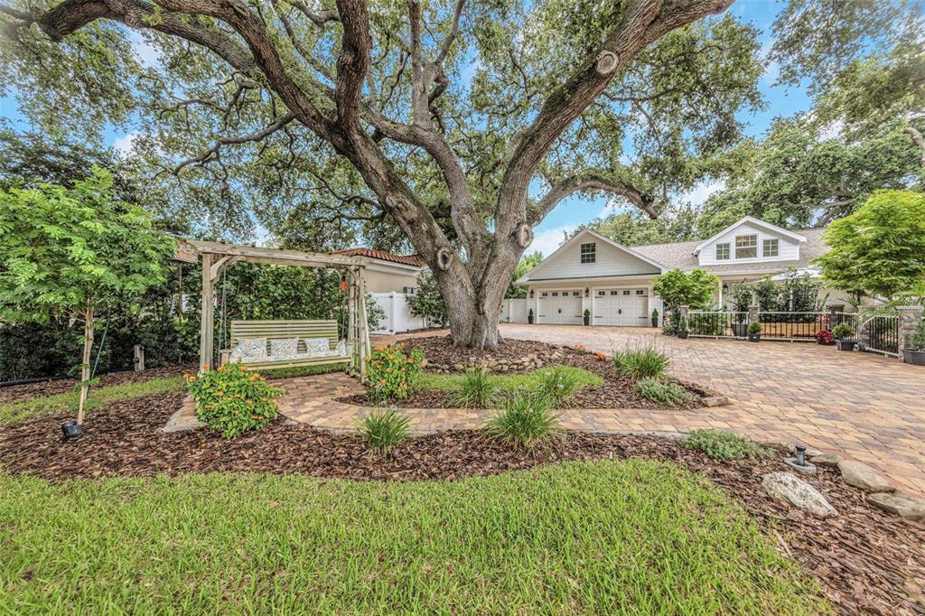 An aerial view shows a house with a swimming pool, patio, and surrounding trees — 411 ROEBLING ROAD S, BELLEAIR, FL
