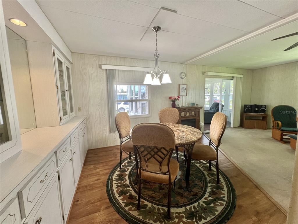 A dining area features wood-paneled walls, a round table with four chairs, and built-in cabinetry — 424 HAWTHORNE BOULEVARD, LEESBURG, FL