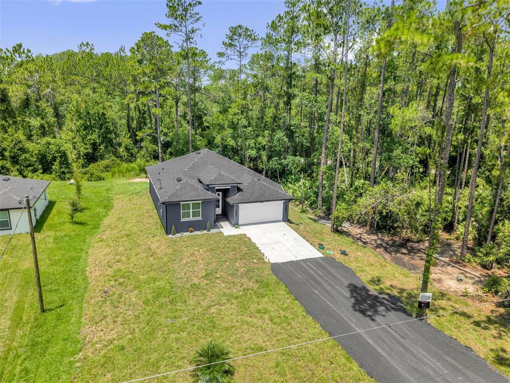An aerial view of a dark gray house with a black roof and asphalt driveway — 2380 CENTRAL PARKWAY, DELAND, FL
