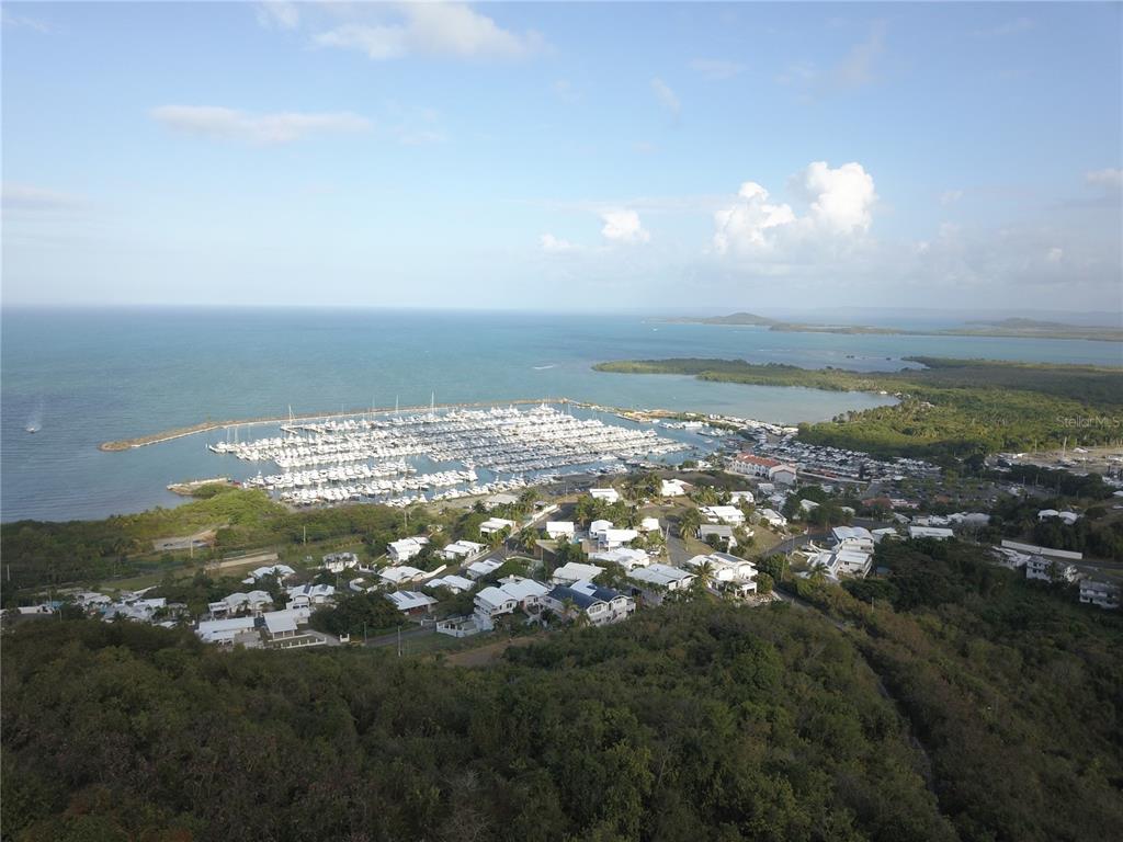 An aerial view shows a large marina filled with boats next to a coastal residential neighborhood — Lot #66 LAS GAVIOTAS CARRETERA 3, CEIBA, FAJARDO 00738 CROSSROAD, FAJARDO, PR