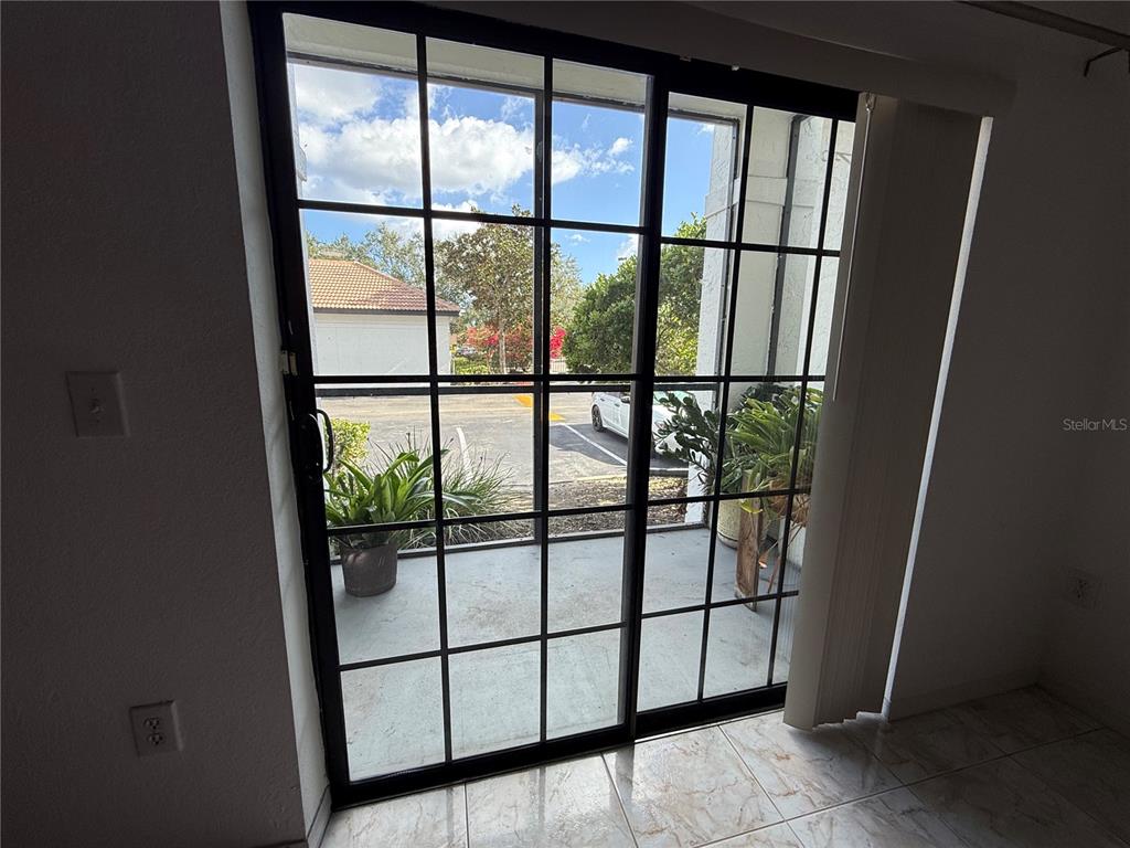 A sliding glass door with a grid pattern opens onto a small concrete patio — 5550 E MICHIGAN STREET UNIT 2119, ORLANDO, FL