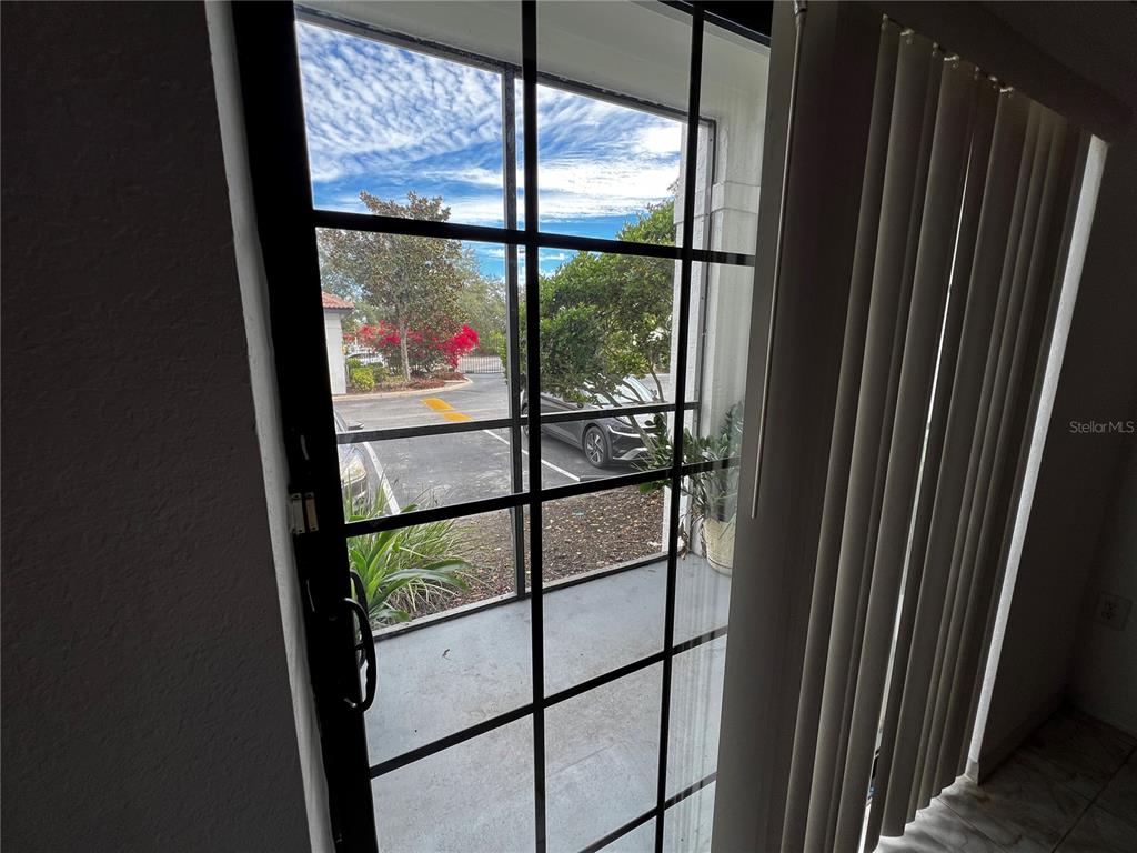A view through a glass door with a black grid looking out onto a parking lot — 5550 E MICHIGAN STREET UNIT 2119, ORLANDO, FL