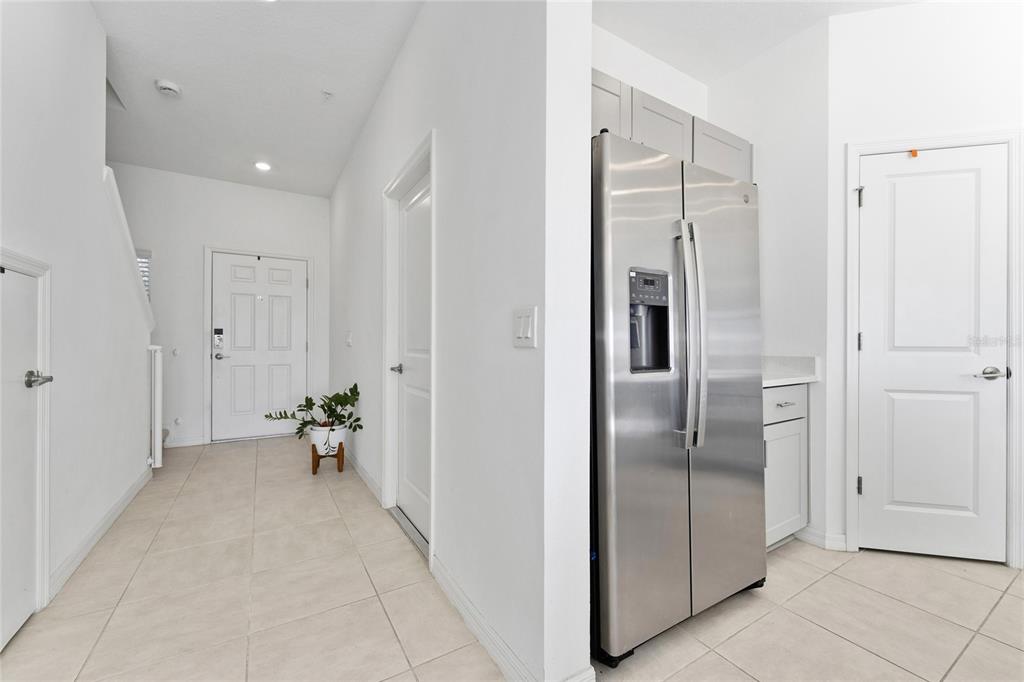 A tiled entryway leads to a stainless steel refrigerator and several white interior doors — 5131 QUAKERS PLACE, ST CLOUD, FL