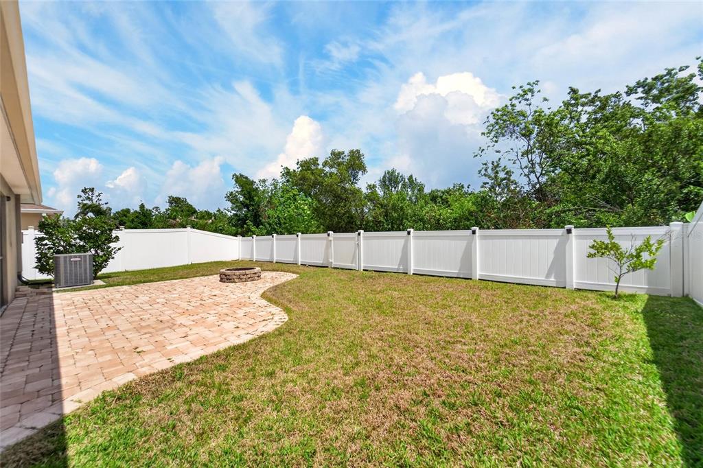 A single-story suburban house features a tan stucco exterior, a two-car garage, and landscaping — 13214 ROYAL PINES AVENUE, RIVERVIEW, FL