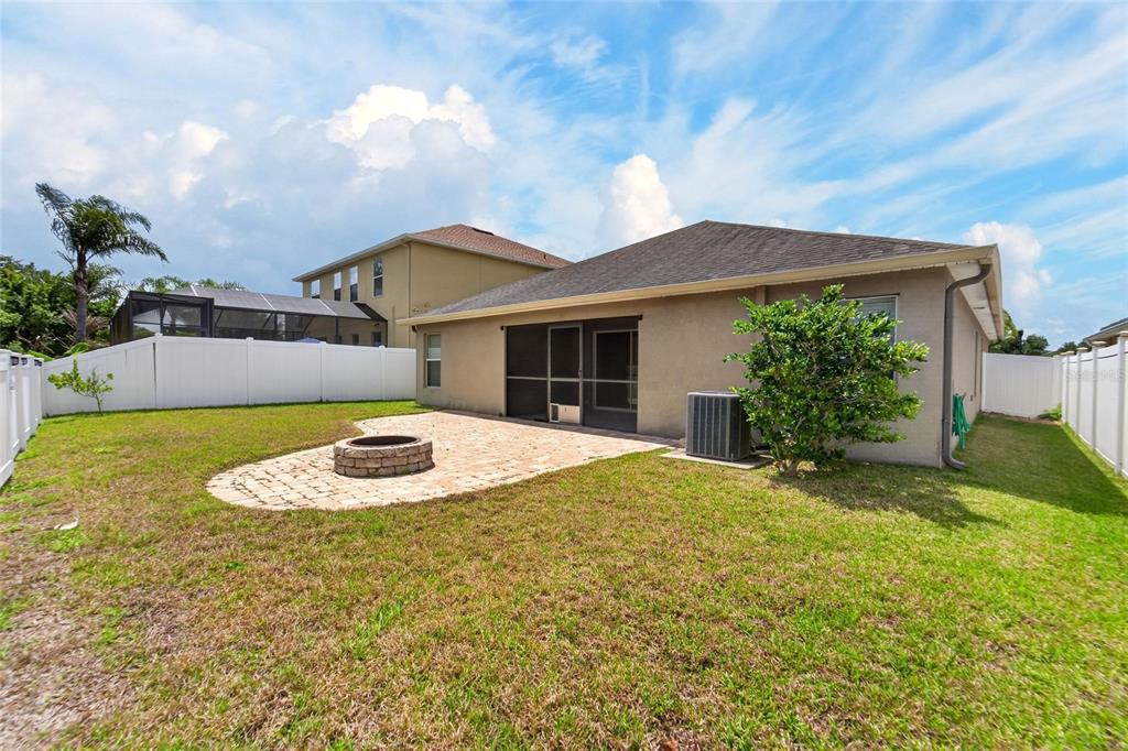 A backyard with a paver patio, a circular fire pit, and a screened-in porch — 13214 ROYAL PINES AVENUE, RIVERVIEW, FL