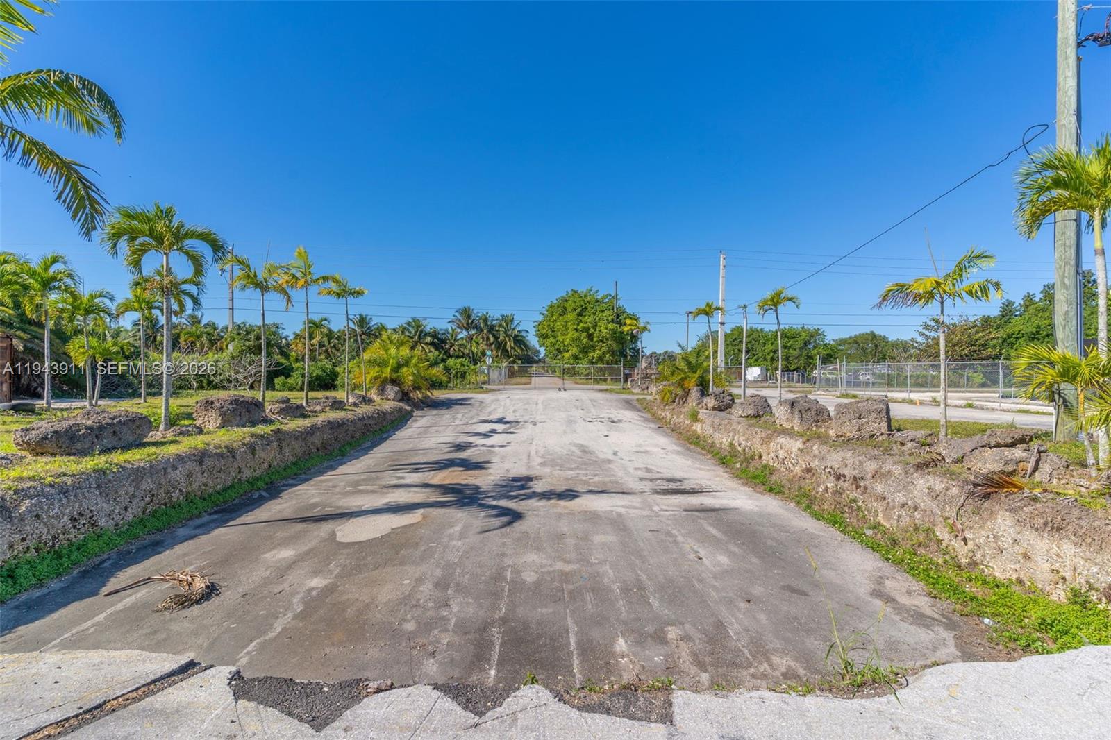 A single-story industrial building with a large open bay door and a paved lot — 20601 SW 194th Ave, Miami FL 33187, MIAMI, FL