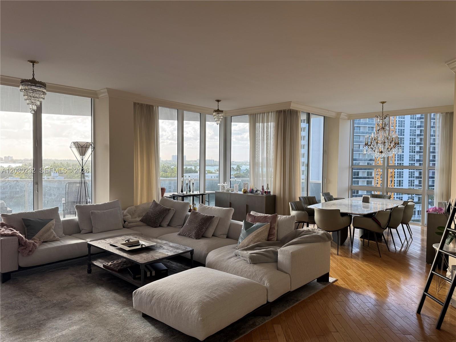 A spacious living and dining area features floor-to-ceiling windows, hardwood floors, and crystal chandeliers — 10225 Collins Ave # 503, Bal Harbour FL 33154, BAL HARBOUR, FL