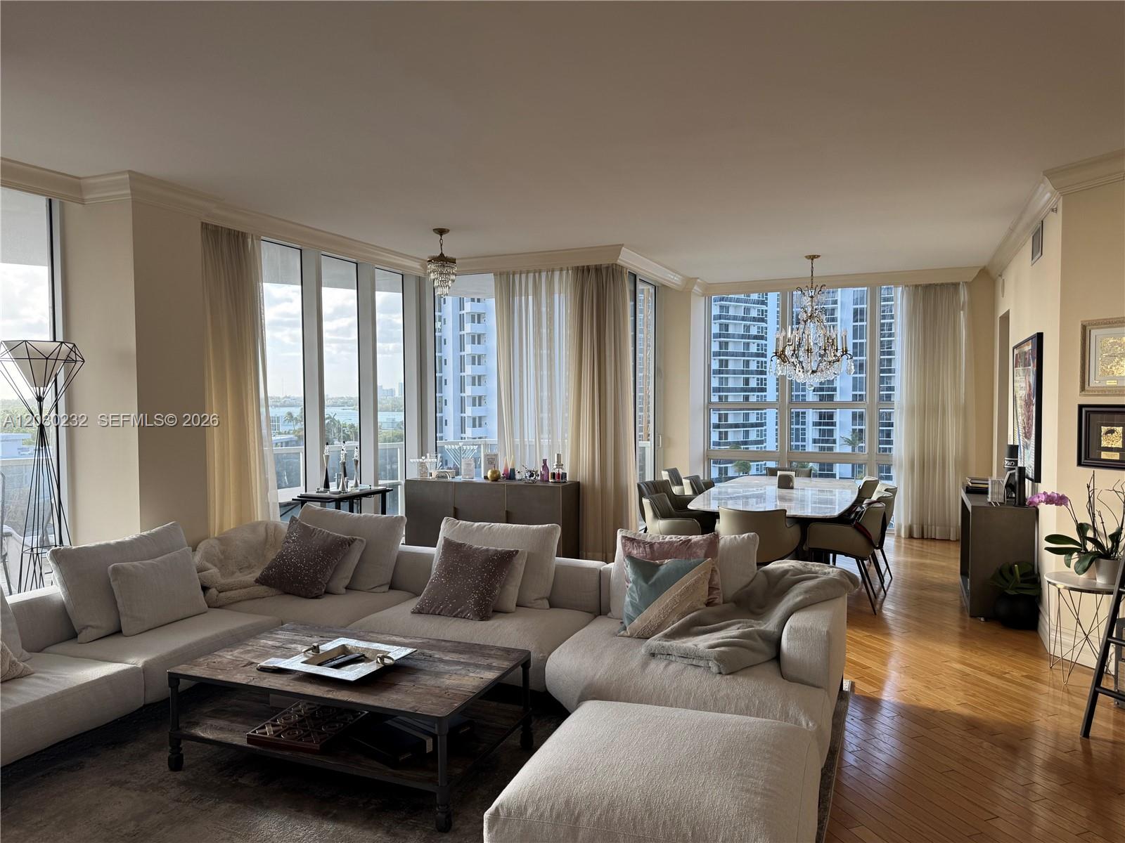 A spacious living and dining area features floor-to-ceiling windows, hardwood floors, and modern furniture — 10225 Collins Ave # 503, Bal Harbour FL 33154, BAL HARBOUR, FL