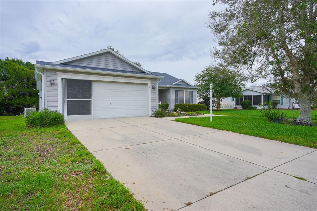 A single-story house with gray siding, a concrete driveway, and a two-car garage — 9345 SE 177TH SIMONS LANE, THE VILLAGES, FL