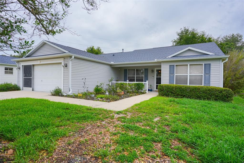 A single-story house with light gray siding, a two-car garage, and a front walkway — 9345 SE 177TH SIMONS LANE, THE VILLAGES, FL