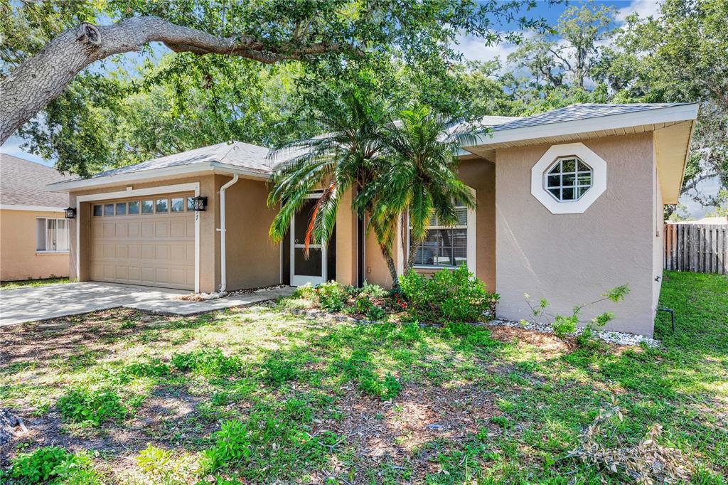 A single-story house with a tan stucco exterior, a garage, and a palm tree — 2757 FEIFFER CIRCLE, SARASOTA, FL