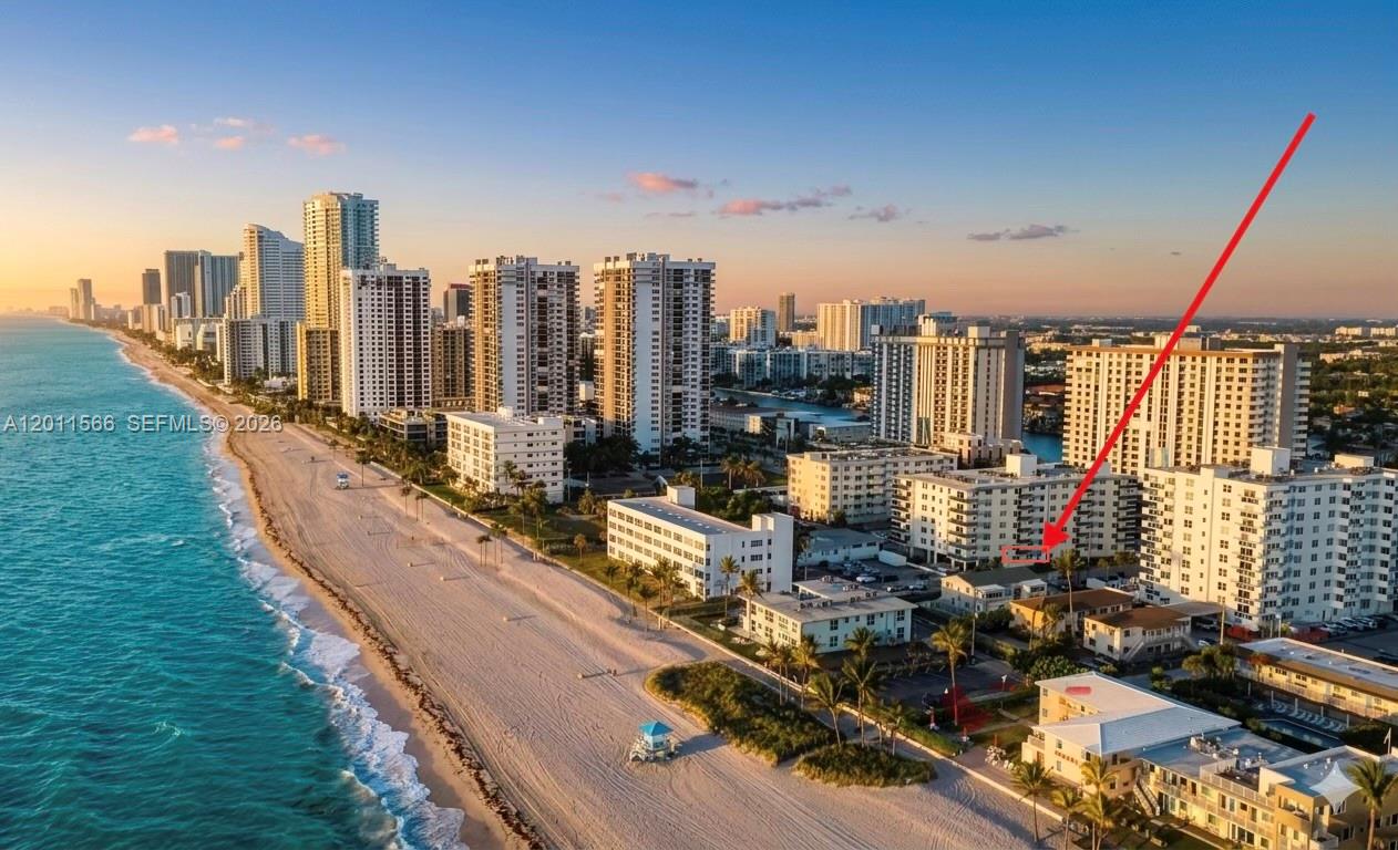 An aerial view shows a coastal city skyline with a red arrow pointing to a building — 1801 S Ocean Dr # 203, Hollywood FL 33019, HOLLYWOOD, FL