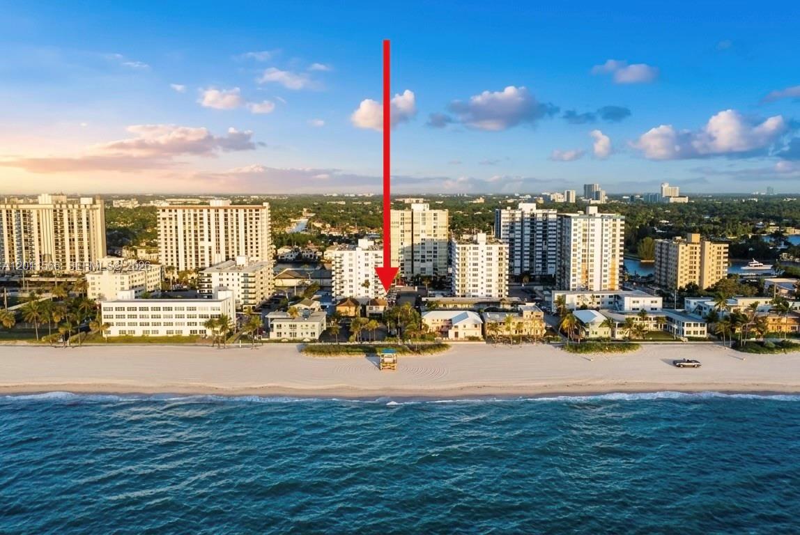 An aerial view shows a beach with several high-rise buildings and a red arrow pointing down — 1801 S Ocean Dr # 203, Hollywood FL 33019, HOLLYWOOD, FL