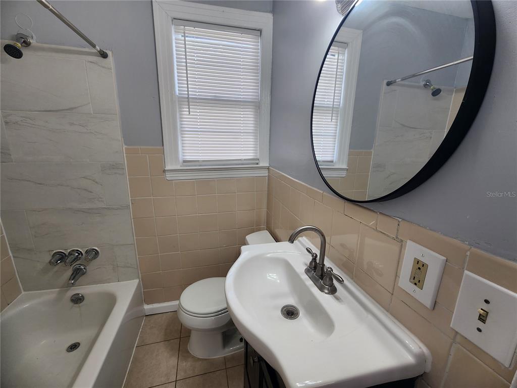 A bathroom features a pedestal sink, a toilet, and a bathtub with tiled walls — 1512 W 31ST STREET, JACKSONVILLE, FL