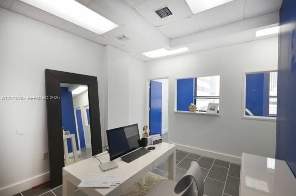 A modern office features a white desk, a large floor mirror, and blue accent walls — 168 SE 1st St # 501, Miami FL 33131, MIAMI, FL