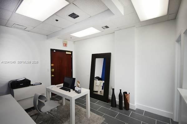 A small office space features a white desk, a chair, a mirror, and tiled flooring — 168 SE 1st St # 501, Miami FL 33131, MIAMI, FL