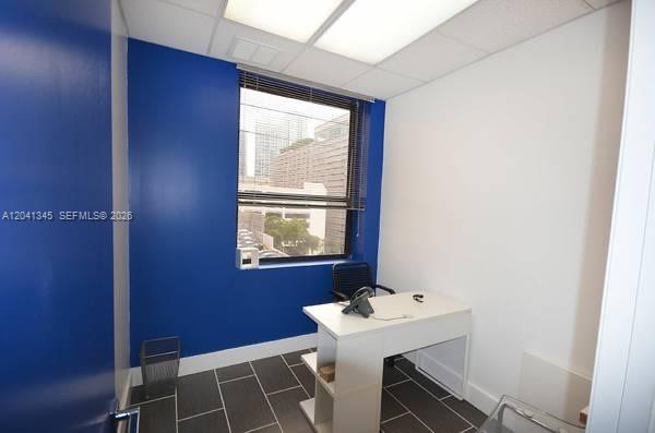 A small office with a white desk, blue accent wall, and dark tile flooring — 168 SE 1st St # 501, Miami FL 33131, MIAMI, FL