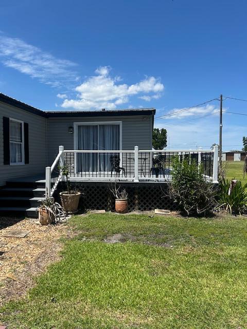 A gray house features a raised wooden deck with white railings and stairs — 4031 SW 9th Way, Okeechobee FL 34974, OKEECHOBEE, FL