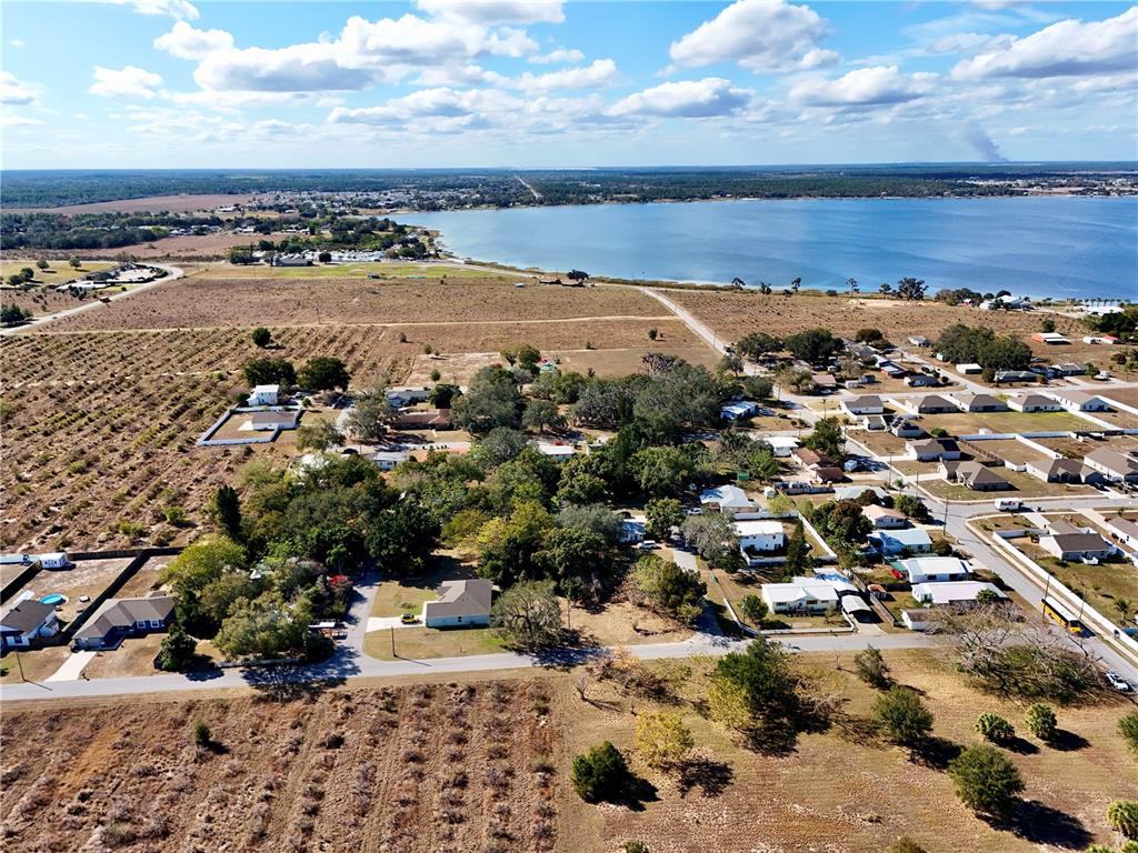 An aerial view shows a residential neighborhood near a large lake and open fields — FLORIDA STREET, FROSTPROOF, FL